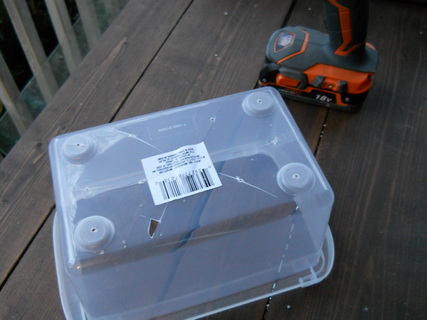 Drilling drainage holes in a plastic storage container from Dollar Tree